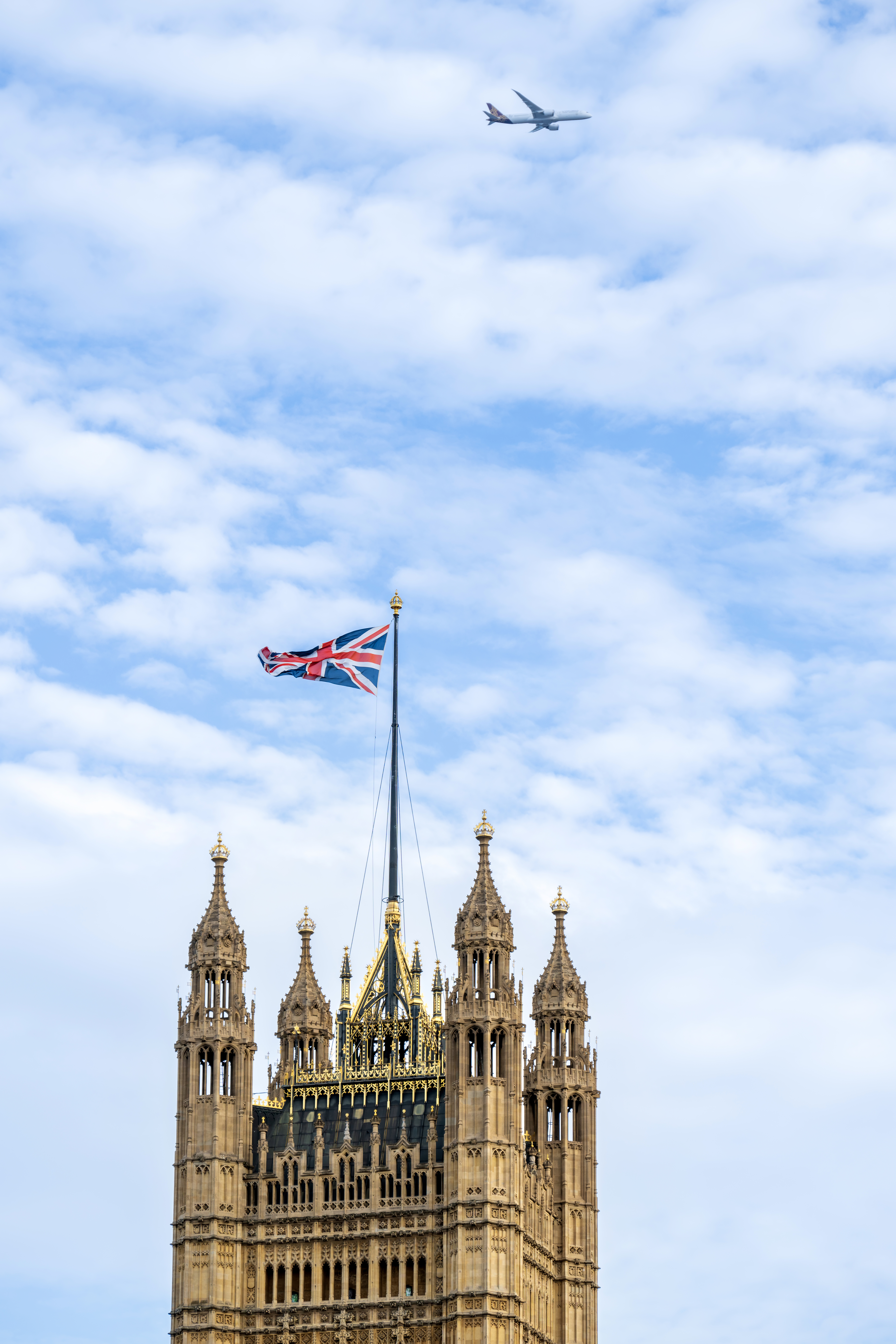 vertical-view-victoria-tower-located-palace-westminster-london-downtown-united-kingdom-blue-sky-with-flying-plane-background
